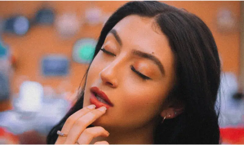 woman closing her eyes holding her lower lip with tooth pain