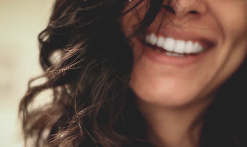 woman's bright smile after porcelain veneers treatment